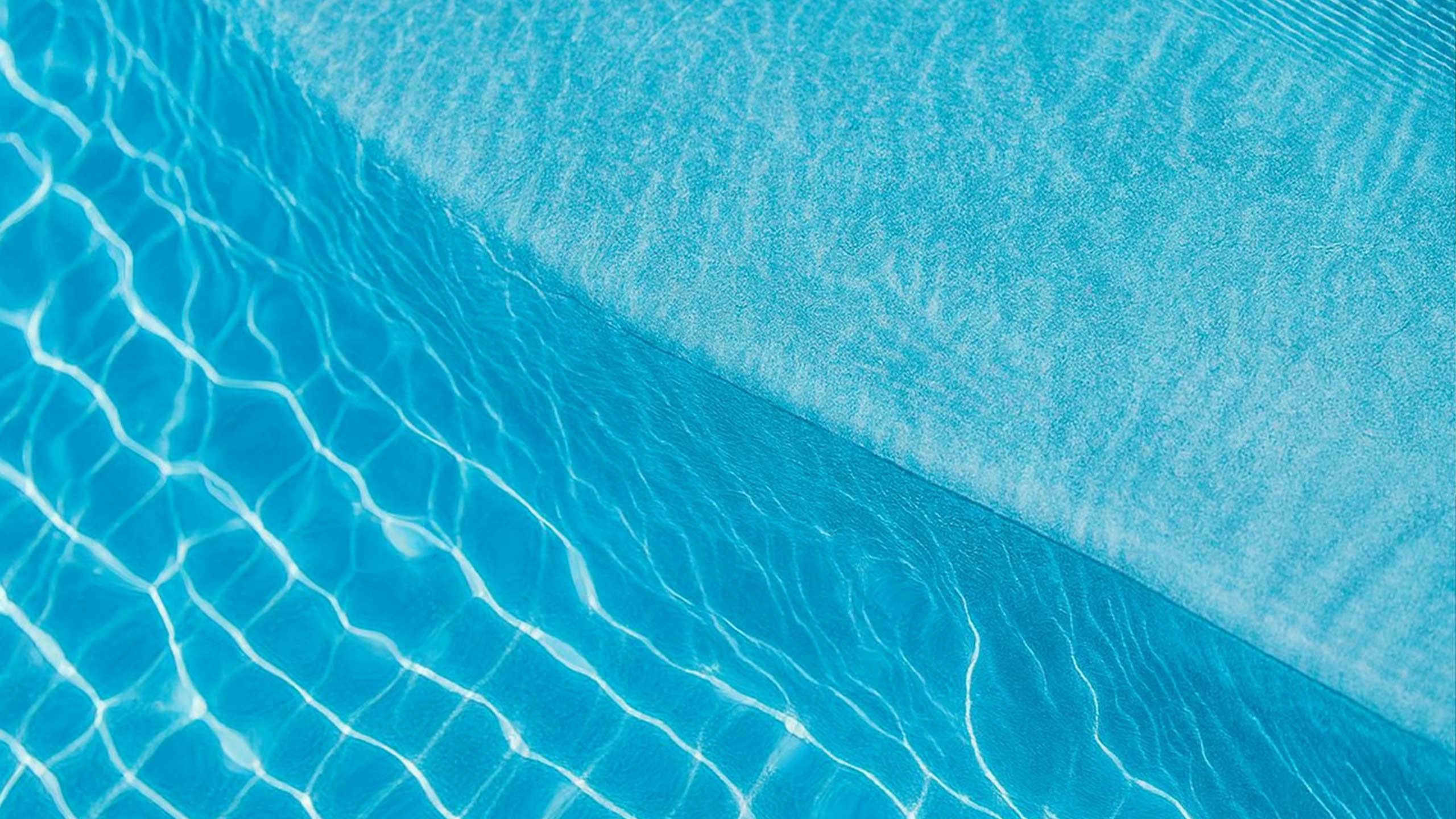 Detailaufnahme der VOGUE Summer Poolfolie mit lebendigem Lichtspiel im Wasser, feiner Struktur und frischen Blautönen – sommerliche Poolästhetik von Aquafolia