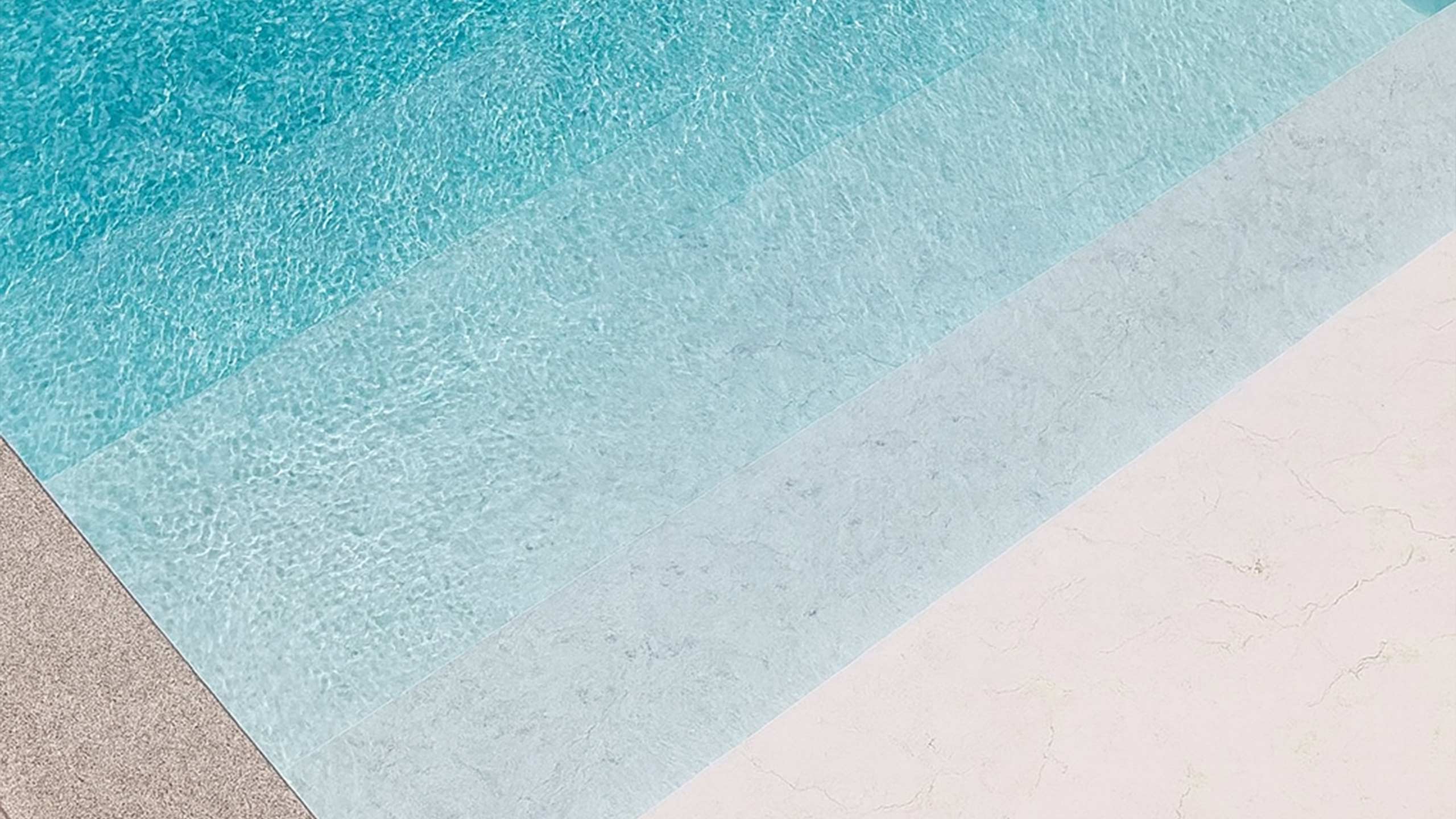 Detailaufnahme der RENOLIT ALKORPLAN TOUCH Vanity Poolfolie von AQUAFOLIA – helle weiße Marmoroptik mit rutschfester 3D-Oberfläche, 2 mm starke Premium-Poolfolie mit feiner Steinstruktur und eleganten Wasserreflexionen